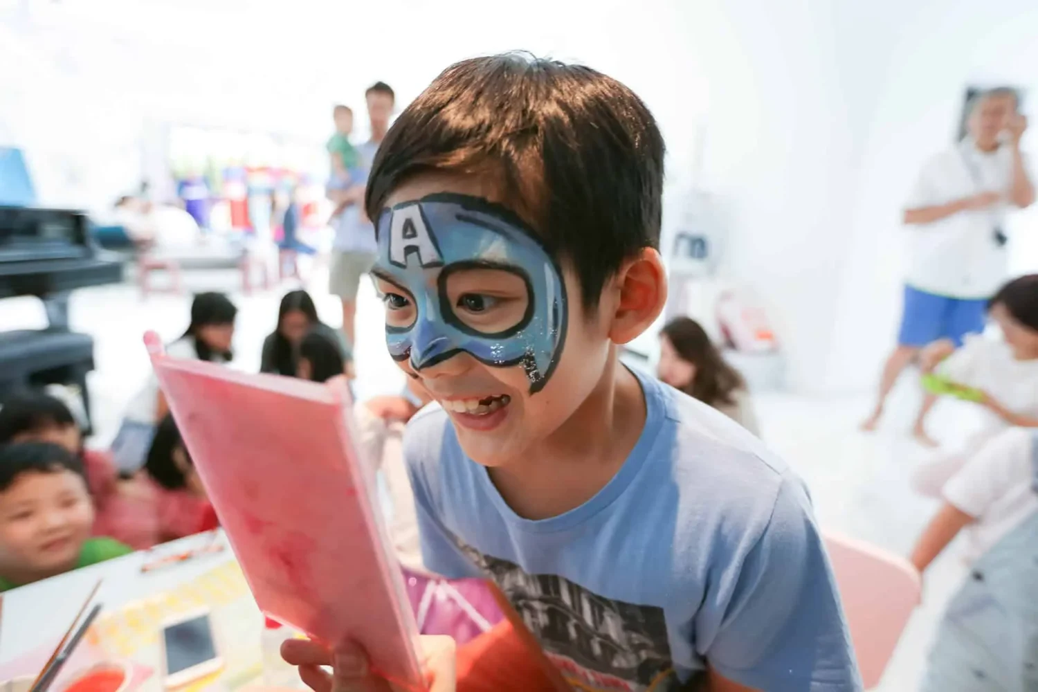 boy looking at his face painting in the mirror